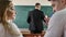 Students talk and interfere with the lesson. The teacher writes formulas on the blackboard