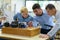 Students and teacher looking at electronic circuit board