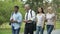 Students and teacher walking in park near college, discussing science project