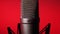 Studio Condenser Microphone Rotates on Red Background.