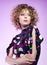 Studio fashion portrait of a young woman in a sparkly dress. Beatiful curly hair