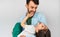 Studio horizontal image of a loving father embraces his cute daughter in his arms. Happy daddy and his little girl playing,