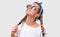 Studio horizontal portrait of pretty blonde young woman wearing trendy sunglasses, white tshirt and blue headband, looking up and