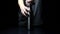 Studio image, close-up of male hand opens a reusable, steel thermo water bottle on black background.