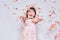 Studio image of happy little girl wearing pink dress with princess crown on head on white background enjoy confetti