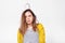 Studio image of upset young woman trying comb unruly damaged hair, posing over white background. People and health