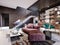 Studio loft design with staircase and dark brick wall. Living room with burgundy upholstered furniture and a modern kitchen