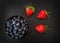 A studio photograph of a bowl of blueberries and strawberries