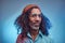 Studio portrait of African Rastafarian male wearing a blue shirt and beanie.
