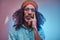 Studio portrait of African Rastafarian male wearing a blue shirt and beanie.