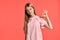 Studio portrait of a beautiful girl blonde teenager in a rosy t-shirt posing on pink background.