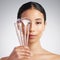 Studio Portrait of a beautiful mixed race woman posing with a collection of makeup brushes during pamper routine