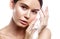 Studio portrait of beautiful woman cleans skin with foam on whit