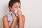 Studio portrait of cute unhealthy Caucasian female with paper napkin sneezing, cathing cold, attractive female with unhealthy look