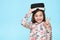 Studio portrait of cute young caucasian girl wearing virtual reality glasses against pastel blue background. Future gadgets.