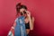 Studio portrait of dreamy tanned woman looking through black sunglasses. Indoor photo of romantic girl in denim jacket