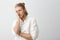 Studio portrait of handsome blond bearded man making face palm with annoyed or tired expression, standing against gray