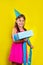 Studio portrait of a little girl wearing a party hat on her birthday. Cute girl open her birthday gift box