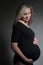 Studio portrait of a pregnant woman on dark background