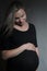 Studio portrait of a pregnant woman on dark background