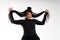 studio portrait of smiling and funny afro latin black woman showing off her braids over gray background