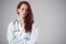 Studio Portrait Of Stressed Young Female Doctor Wearing White Coat Against Plain Background