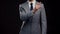 Studio portrait of successful and smart businessman in suit and tie. Man in formal wear over black background.