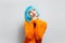 Studio portrait of young sweet girl with blue hair thinking positive, looking up, blowing kisses against white background.