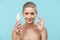 Studio portrait of a young woman holding a bottle of gentle foam facial cleanser. Beauty products and skin care concept.