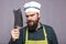 Studio shot of an angry bearded man holding a butcher knife