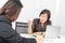 Studio shot of Asian, senior businesswoman with laptop, sitting with two young staffs in board room in office, boss making serious