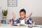 Studio shot of attractive little girl of mulatta with braids of frizzy. She reads the textbook and does not understand the text