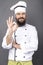 Studio shot of a bearded chef showing OK sign