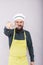 Studio shot of a bearded young man with apron and cook hat holding a big sharp knife