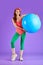 Studio shot of beautiful sporty student girl holding blue fitness ball