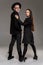 Studio shot of a beautiful young woman and man posing over a gray studio background.