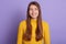 Studio shot of charming lady with long beautiful hair looking directly at camera, adorable lady wearing yellow casual shirt, girl