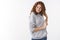 Studio shot cheeky cheerful redhead charismatic young girl wearing grey hoodie smiling silly flirting giggling playing