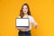 Studio shot of cheerful beautiful Asian woman in white t-shirt and holding laptop mockup.