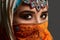 Studio shot of a chrming female wearing the colorful hijab decorated with sequins and jewelry. Arabic style.