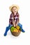 Studio shot of cute little girl, emotive kid in image of farmer, gardener holding big basket of vegetables isolated on