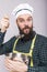 Studio shot of an expressive chef with beard tasting soup with