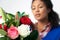 Studio Shot Of Female Florist Arranging Bouquet Of Lillies And Roses Against White Background