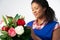 Studio Shot Of Female Florist Arranging Bouquet Of Lillies And Roses Against White Background