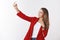 Studio shot gorgeous confident sassy successful young businesswoman wearing red jacket extending hand standing profile