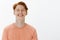 Studio shot of handsome confident adult redhead guy with freckles and bright smile, grinning joyfully and gazing