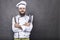 Studio shot of a happy bearded young chef holding sharp knives