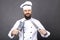 Studio shot of a happy bearded young chef holding sharp knives