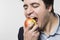 Studio shot of happy person eating an apple