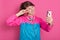 Studio shot of happy teenage girl posing isolated over rose studio background, winsome female showing v sign while making selfie,